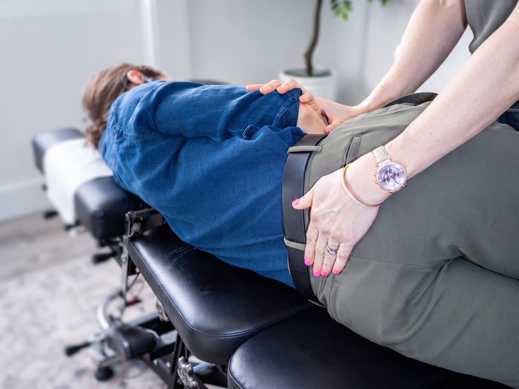 Pelvic Floor Physiotherapy in Waterloo: a practitioner’s hands at a patient’s hip, the patient lying on their side