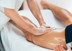 Massage therapy session on leg of male athlete