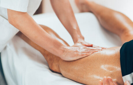 Massage therapy session on leg of male athlete